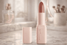 Maybelline New York serum lipstick with cap beside tube on marble countertop